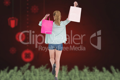 Composite image of rear view of young woman with shopping bags