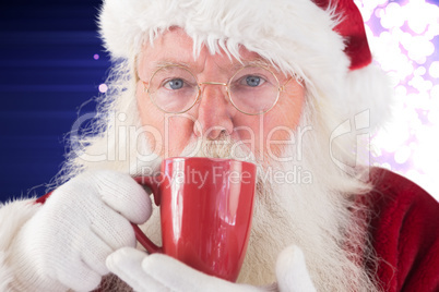 Composite image of santa drinks from a red cup