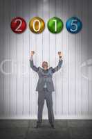 Composite image of happy businessman cheering