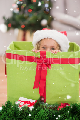 Composite image of cute little girl sitting in giant christmas gift