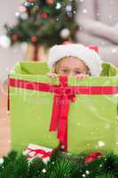 Composite image of cute little girl sitting in giant christmas gift