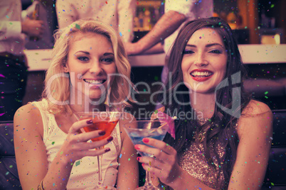 Composite image of happy friends having a drink together