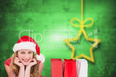 Composite image of smiling woman lying between shopping bags