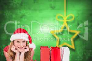 Composite image of smiling woman lying between shopping bags