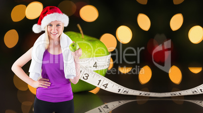 Composite image of festive fit blonde smiling at camera holding