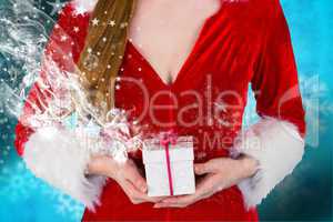Composite image of pretty girl in santa costume holding gift box