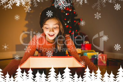 Composite image of little girl opening a glowing christmas gift