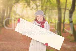 Composite image of happy blonde in winter clothes showing card