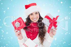 Composite image of happy brunette holding christmas gifts