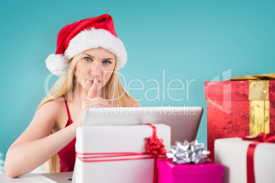 Composite image of festive blonde shopping online with laptop