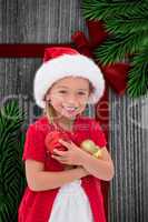 Composite image of cute little girl wearing santa hat holding ba