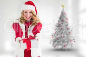 Composite image of festive blonde giving red gift