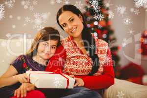 Composite image of festive mother and daughter holding christmas