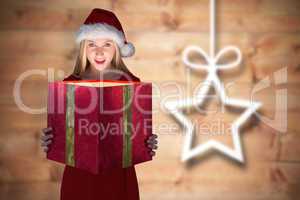 Composite image of festive blonde holding a gift