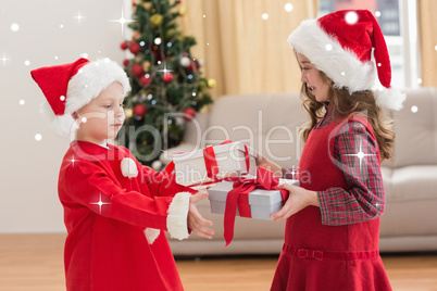 Composite image of festive little siblings holding gifts Composite image of festive little siblings holding gifts