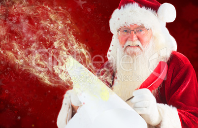 Composite image of santa claus writing on scroll