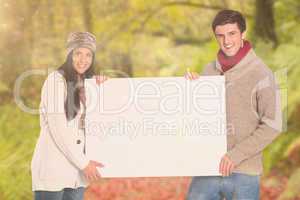 Composite image of young couple holding a poster