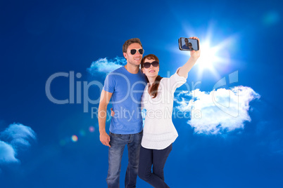 Composite image of couple using camera for picture