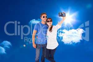 Composite image of couple using camera for picture