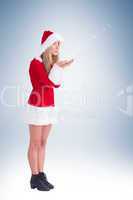 Pretty santa girl blowing over hands