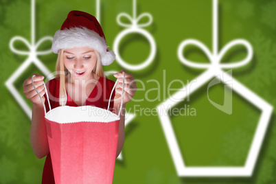 Composite image of festive blonde opening a gift bag