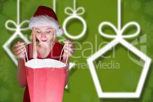 Composite image of festive blonde opening a gift bag