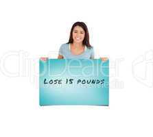 Composite image of attractive woman holding a  board