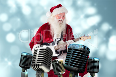 Composite image of santa claus has fun with a guitar
