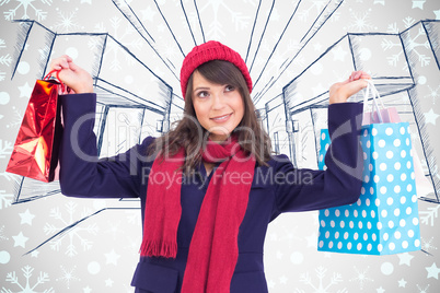 Composite image of pretty brunette holding up shopping bags