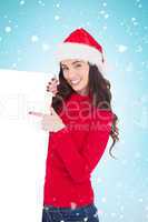 Composite image of smiling brunette in santa hat pointing white