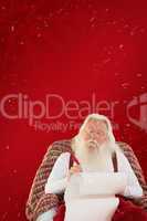 Composite image of father christmas writing list with a quill