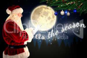 Composite image of santa uses a tablet pc