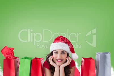 Composite image of festive brunette lying near shopping bags