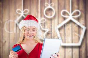 Composite image of festive blonde shopping online with tablet