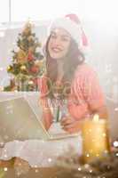 Composite image of festive brown hair shopping online with laptop at christmas