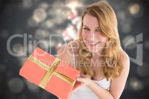 Composite image of cute blonde holding a gift