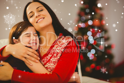 Composite image of festive mother and daughter hugging on couch