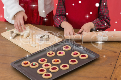 Composite image of festive little girls making christmas cookies