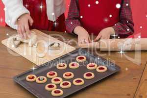 Composite image of festive little girls making christmas cookies