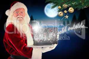 Composite image of santa claus presents a laptop