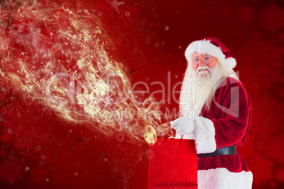 Composite image of santa carries red gift bag