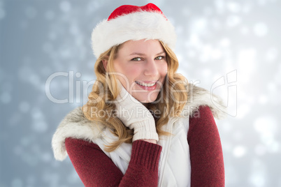 Composite image of festive blonde smiling in santa hat