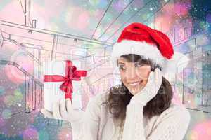 Composite image of pretty santa girl holding gift