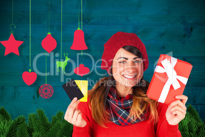 Composite image of smiling brunette holding gift and cards