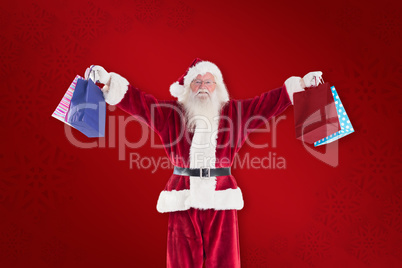 Composite image of santa holds some bags for chistmas