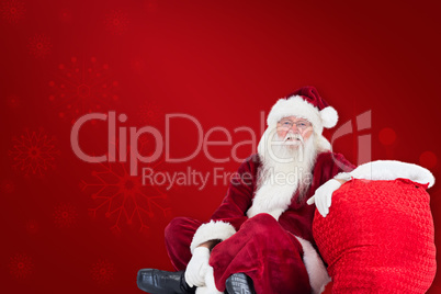 Composite image of santa sits next to his bag