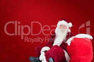 Composite image of santa sits next to his bag