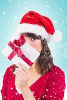 Composite image of festive woman looking at camera holding a gif