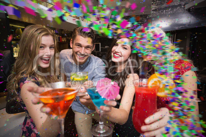 Composite image of happy friends having a drink together