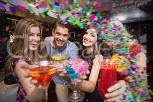 Composite image of happy friends having a drink together